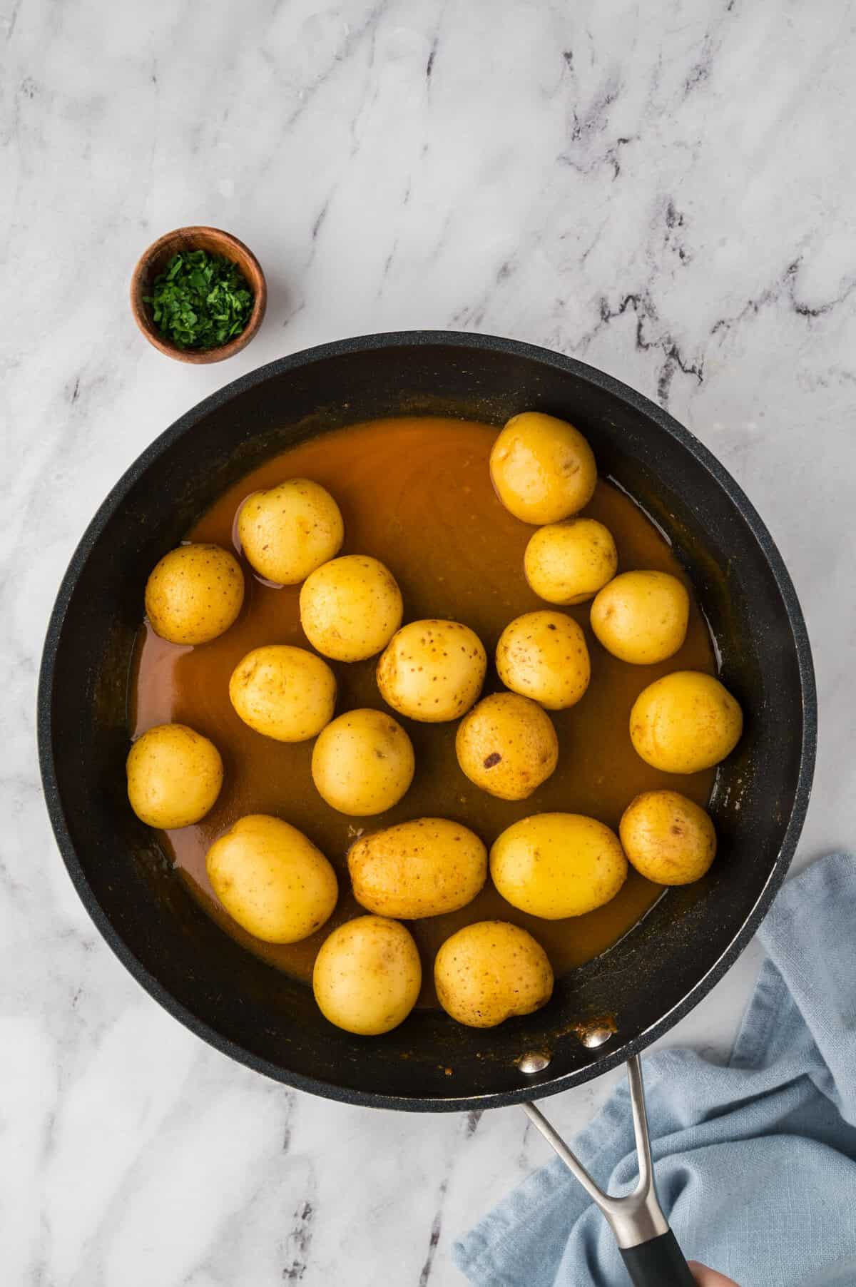 Potatoes in broth in skillet.