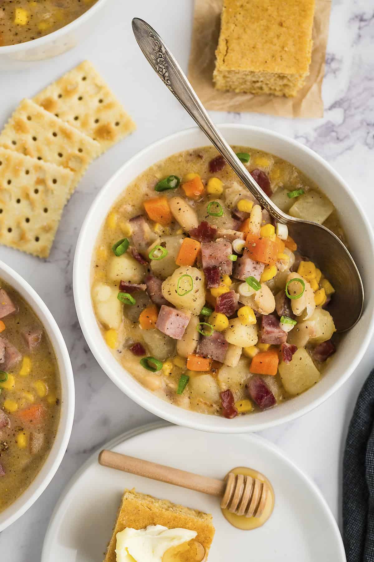 Overhead view of ham and corn chowder in bowl with spoon.