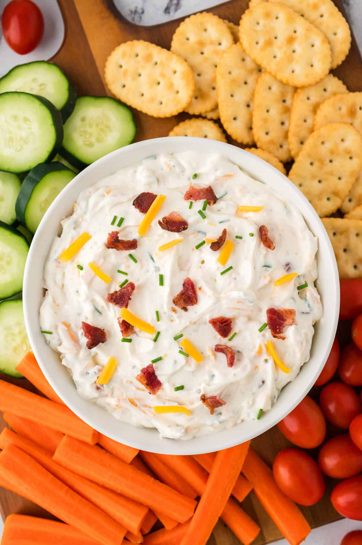 Bacon cheddar ranch dip sourrounded by crackers and vegetables.