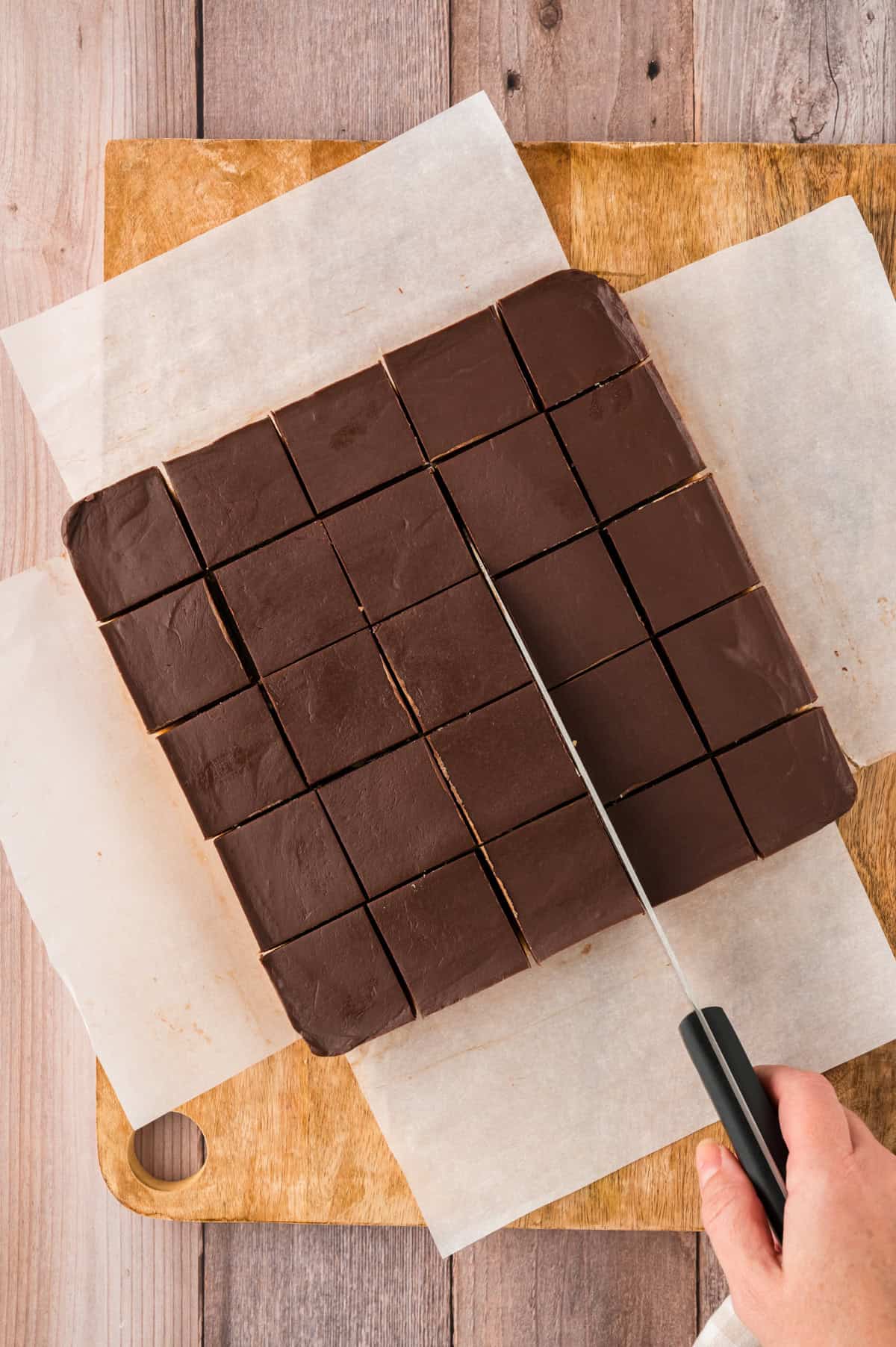 Chocolate peanut butter fudge being cut into squares.