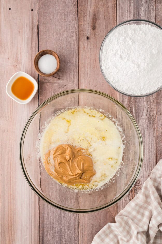 Melted butter and peanut butter in glass mixing bowl.