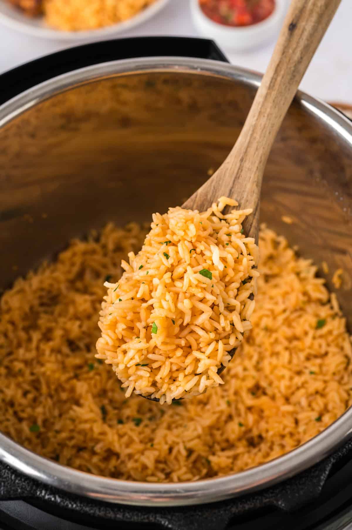 Wooden spoon full of Mexican rice in Instant Pot.