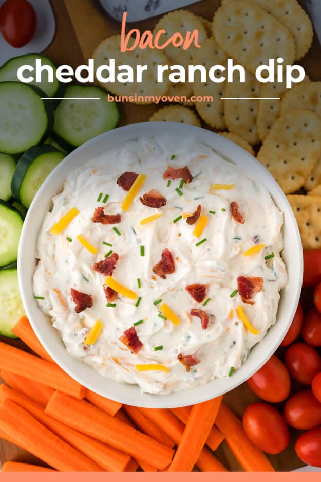 Bacon cheddar ranch dip in bowl surrounded by vegetables.