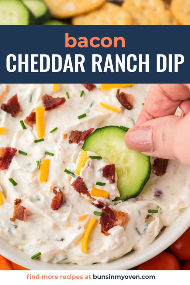 Cucumber being dipped into ranch dip.