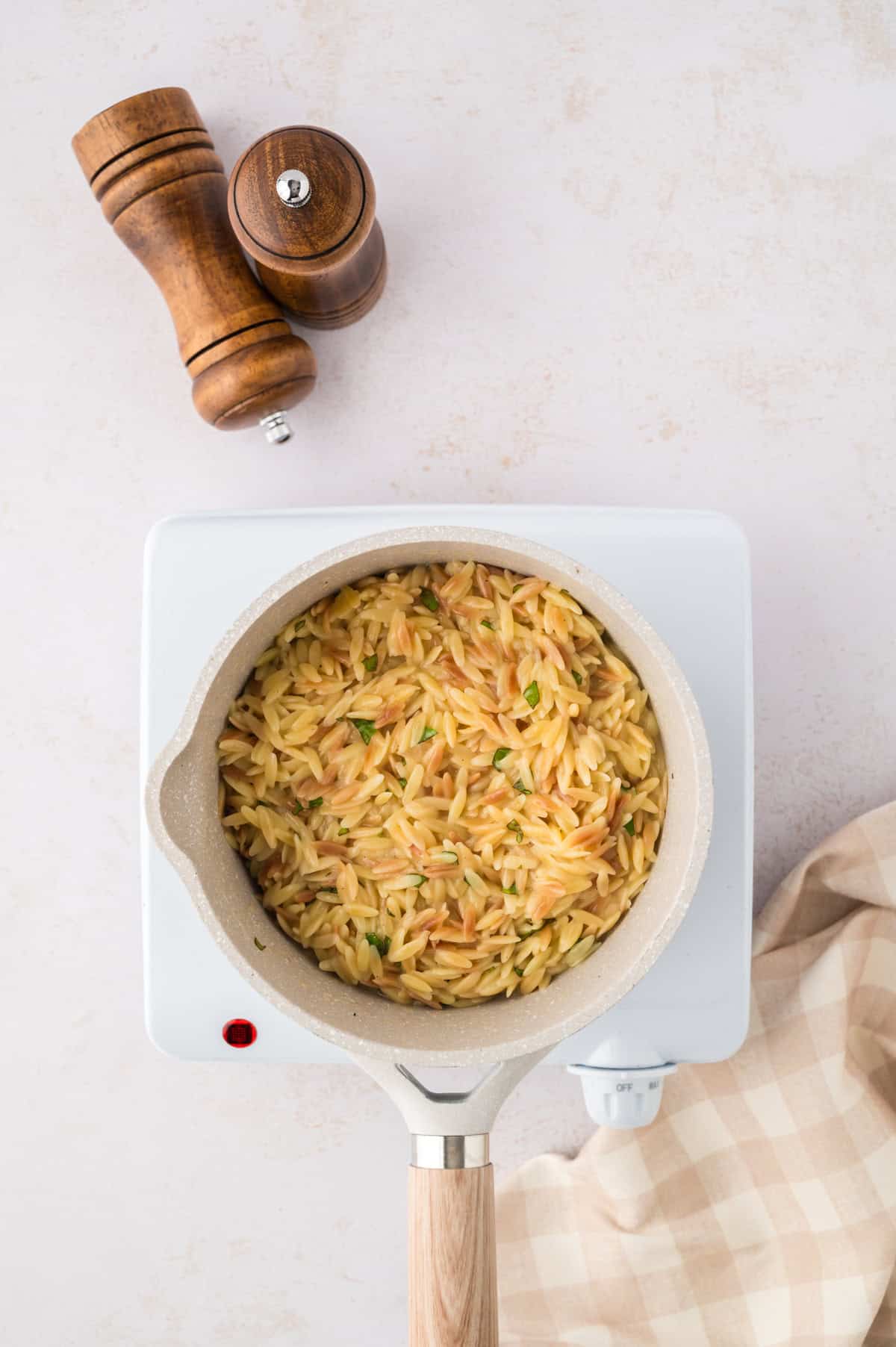 Cheesy orzo in saucepan.