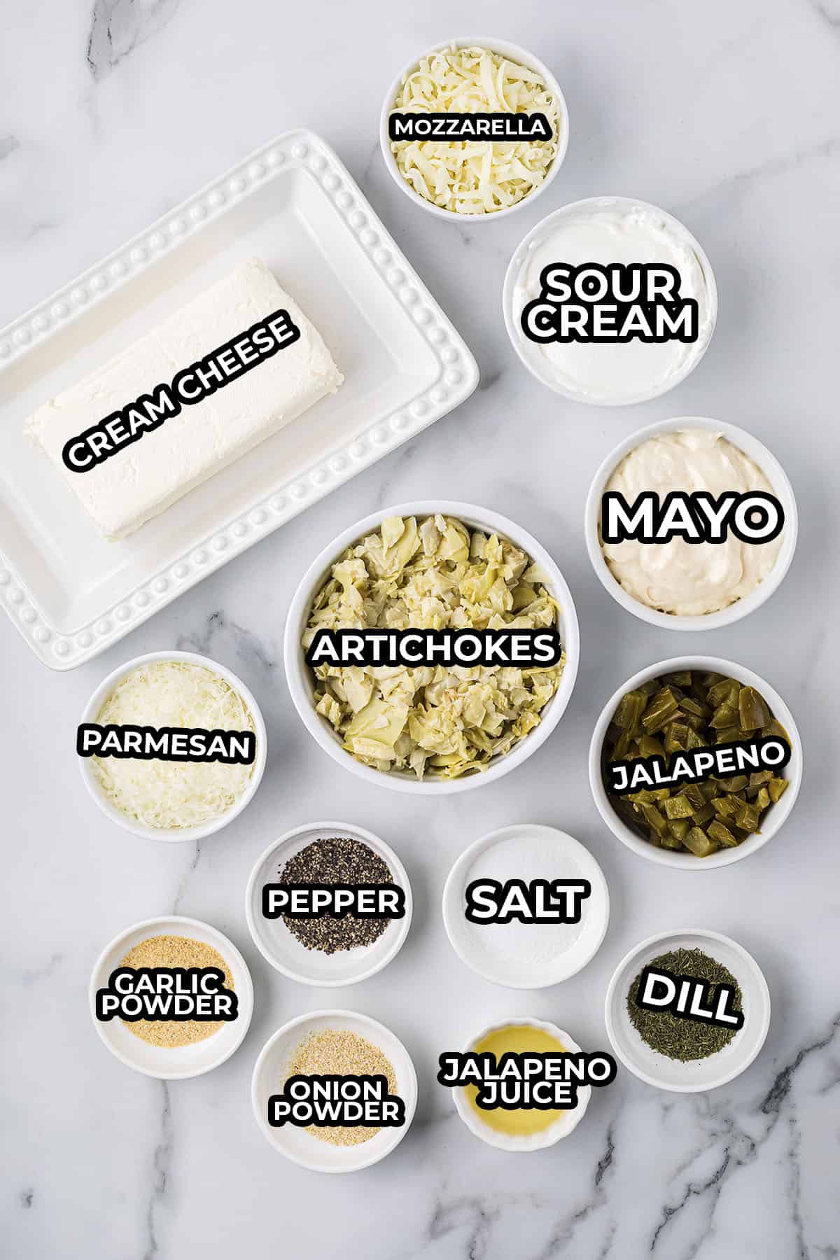 Ingredients for jalapeno artichoke dip laid out in small dishes on table.