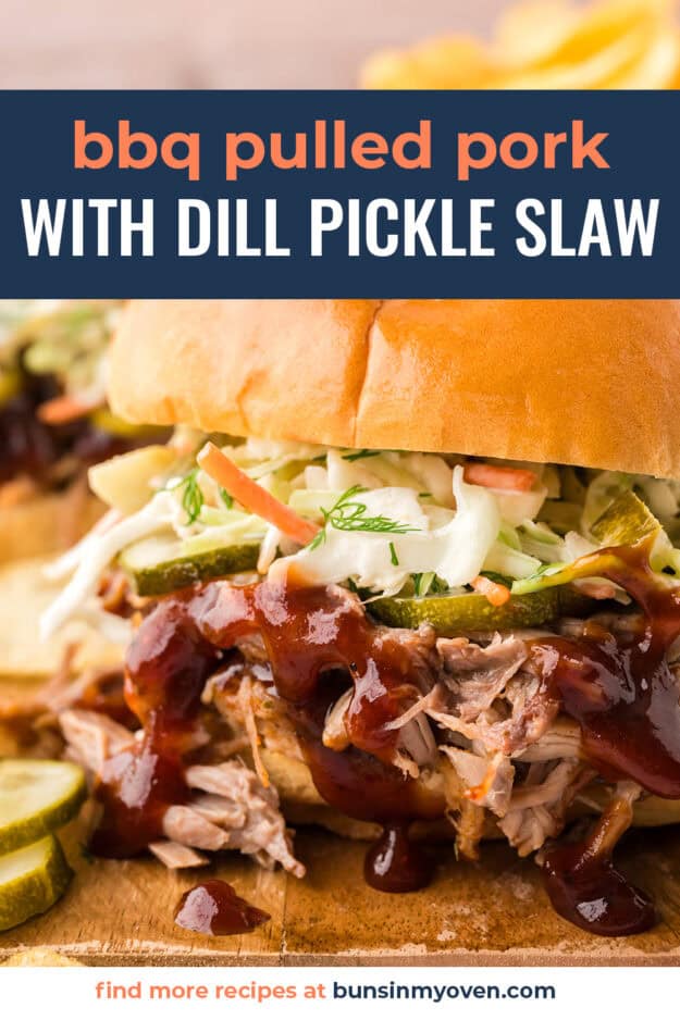 Close up of pulled pork on bun with slaw and pickles.