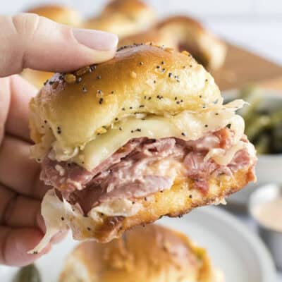 Hand holding a reuben slider.