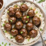 Plate full of firecracker meatballs over rice.